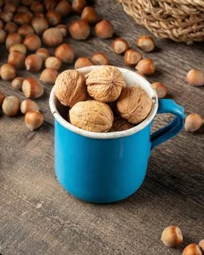 Walnuts in a pot, with hazelnuts in the background 写真素材