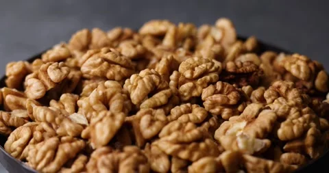 Walnuts rotating in loop macro shot with tilt shift lens on gray background Video stock 320980258