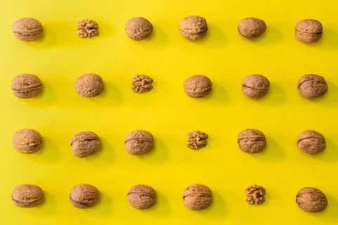 Walnuts in rows, pattern of walnuts on a bright bold yellow background Stock Photos