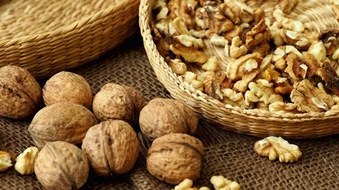 Walnuts on rustic natural burlap, Walnut kernels in wicker basket Stock Footage 97042551