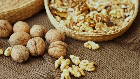 Walnuts on rustic natural burlap, Walnut kernels in wicker basket. Stock Footage 123299736