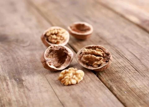 Walnuts on a rustic wooden table - close up Stock Photos
