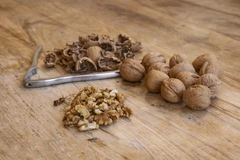 Walnuts on rustic wooden table with nutcracker Stock Photos