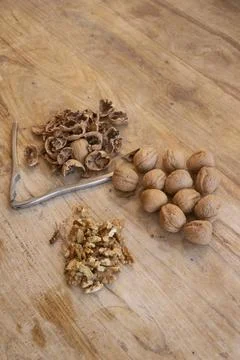 Walnuts on rustic wooden table with nutcracker Stock Photos