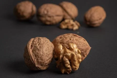 Walnuts scattered on a dark background, macro Foto stock