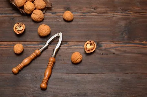 Walnuts in the shell and a nutcracker on a wooden background,copy space Stock Photos