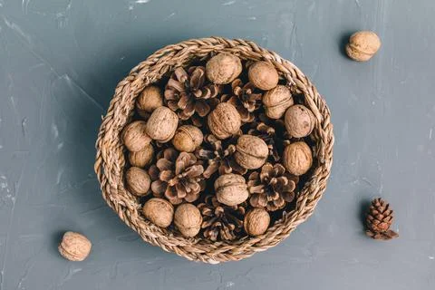 Walnuts in shell and pine cones in basket as Christmas table decoration Stock Photos