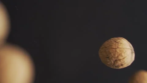 Walnuts in shell fly on a black background. Nutrients and healthy eating Stock Footage 255607213