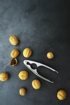 Walnuts in a shell on a gray background. Nutcracker and scattering of nuts. Foto stock