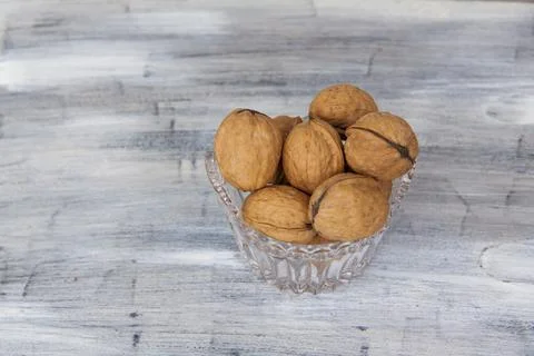 Walnuts in a shell on a painted background in a crystal vase. Healthy nuts. Stock Photos