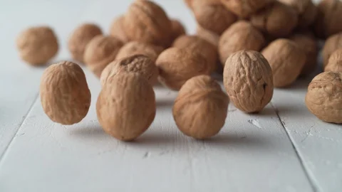Walnuts in shell rolling on the table. Slow Motion. Stock Footage 89608160
