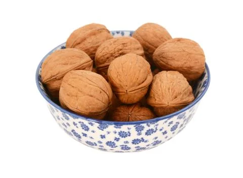 Walnuts in shells, in a blue and white china bowl Stock Photos