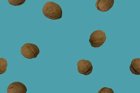 Walnuts in shells on a blue background - top view. Seamless pattern. Stock Photos