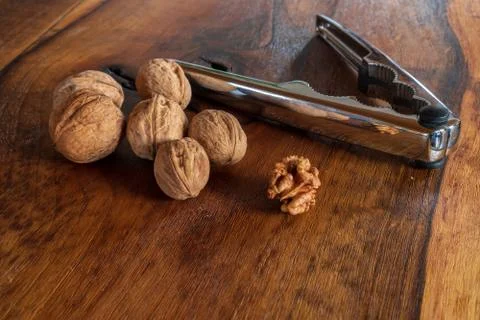 Walnuts with silver nutcracker on wooden background. It originated from a cro Foto stock