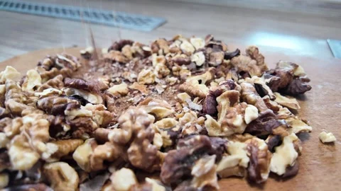 Walnuts slow motion video. Whole walnut pieces falling onto white table top.. Stock Footage 301871760