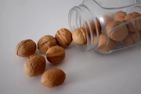 Walnuts spilled from a can on a white table Stock Photos