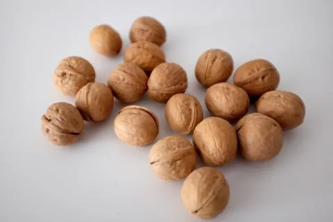 Walnuts spilled on a white table Stock Photos