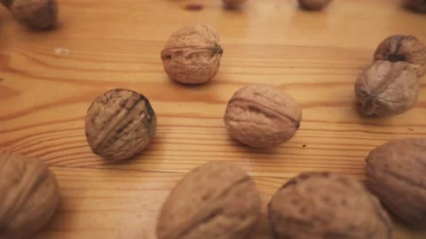 Walnuts in their shells are crumbling on the wooden floor. Stock Footage 186977833