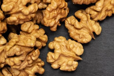 Walnuts. Walnut kernels on dark black stone background. Top view, flat lay Stock Photos