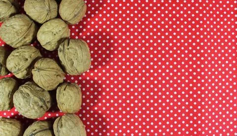 Walnuts on white dotted red background Foto stock