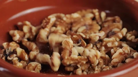 Walnuts without shell falling down on red plate close-up . Peeled nuts. Healthy Vidéo 273722422