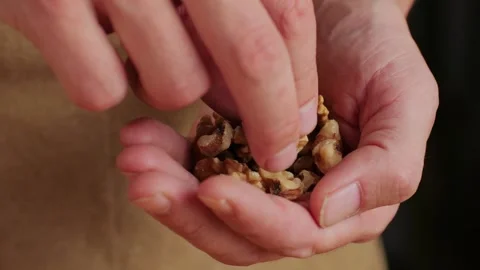 Walnuts without shell in man hand close-up macro. Peeled nuts. Healthy snacks Stock Footage 256857496