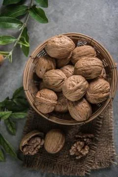 Walnuts in wooden bowl. Whole walnut on table Stock Photos