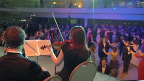 Waltzing pairs dancing at ball. View from scene chamber orchestra Stock Footage 247499737