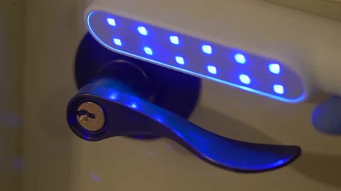Wand sterilizer with UV C light used on door lever handle during the coronavirus Stock Footage 131684431
