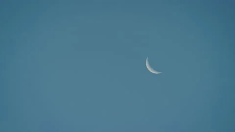 Waning crescent moon in the setting sky Stock Footage 153142748
