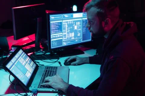 Wanted hackers coding virus ransomware using laptops and computers in the Stock Photos