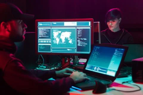 Wanted hackers coding virus ransomware using laptops and computers in the Stock Photos
