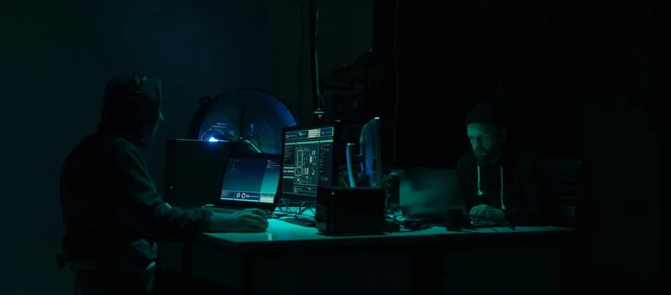 Wanted hackers coding virus ransomware using laptops and computers. Cyber attack Stock Photos