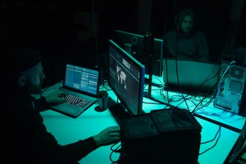 Wanted hackers coding virus ransomware using laptops and computers. Cyber attack Stock Photos