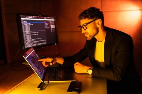 Wanted hackers coding virus ransomware using laptops and computers. Stock Photos