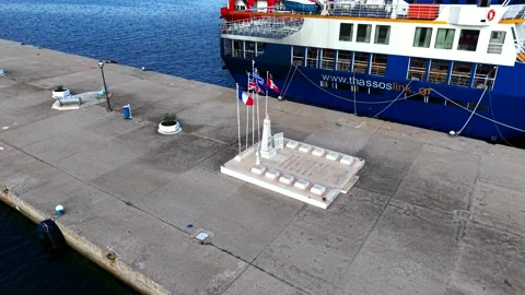 War memorial with flags on the harbour pier of Skala Prinos, Thassos Stock-Footage 347173606