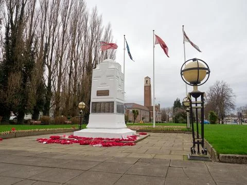 War memorial surrounded by flags and wreaths on a cloudy day. Swinton, Manc.. Stock Photos