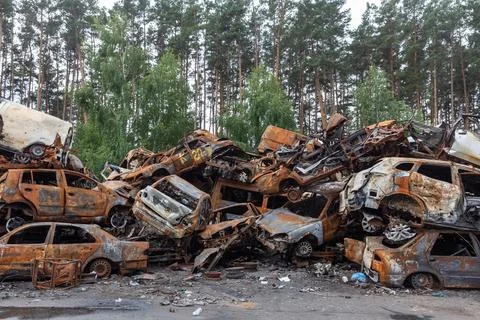 War in Ukraine. Car graveyard in Irpin. Shot cars of civilians. Stock Photos