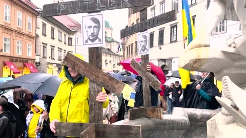 War in Ukraine, protests. Man with across and photo of Putin as Hitler. Putler 動画素材 171197979