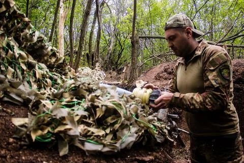 War in Ukraine, Ukrainian serviceman preparing a shell for a 120mm, Bakhmut.. Stock Photos