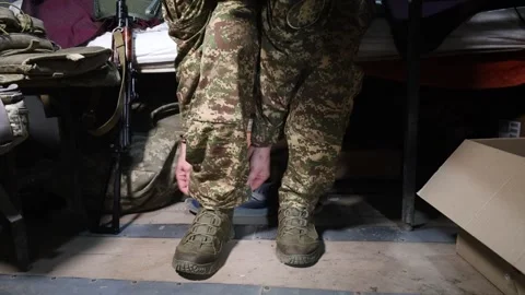 A war veteran with a prosthesis adjusts his military uniform instead of a leg. Stock Footage 296804310