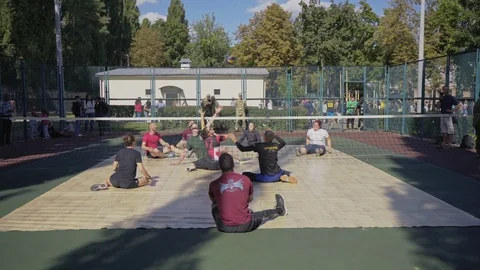 War veterans play sit-down volleyball on the court. Handicapped in sport. 스톡 동영상 120776274