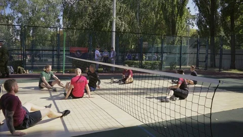War veterans play sit-down volleyball on the court. Handicapped in sport. 스톡 동영상 121041984