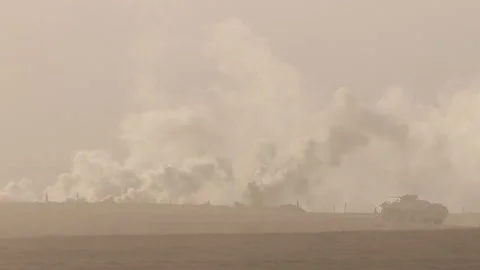 A war zone in the desert, there is a battle, the smoke from the shots creeps Stock Footage 124012808