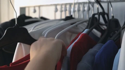 Wardrobe hanger with multi-colored clothes in the store. colorful outfits hang Stock Footage 85176228