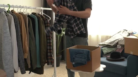 Wardrobe ore closet for man sorting clothes for charity Stock Footage 197181096