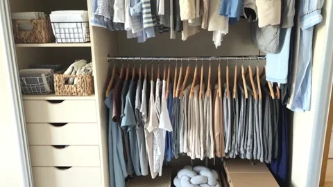 Wardrobe with perfect order clothes in blue and light shades on the hangers and Stock Footage 245965190