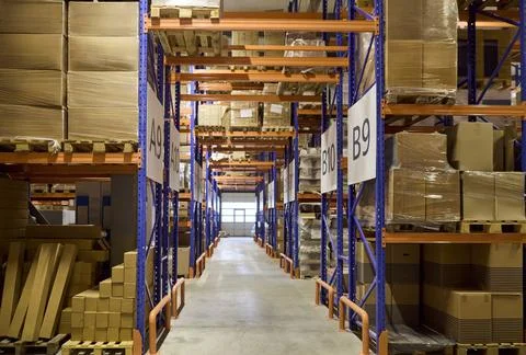 Warehouse aisle with racks and boxes for inventory storage and logistics Stock Photos