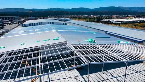 Warehouse construction process with metal structures and roofs Stock Photos