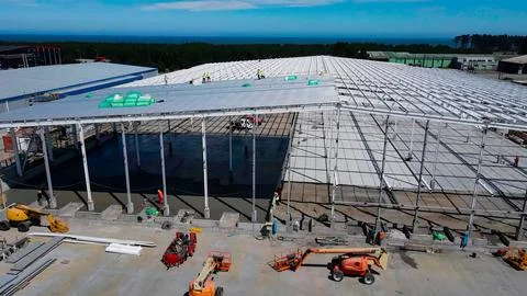Warehouse construction process with metal structures and roofs Stock Photos